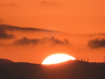 Scenic view of silhouette landscape against orange sky