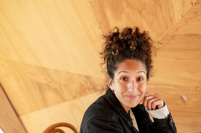 Happy latin woman smiling while sitting indoors.