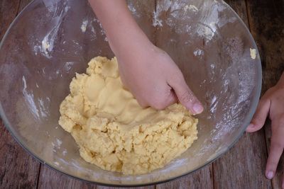 Midsection of woman preparing food in bowl on table