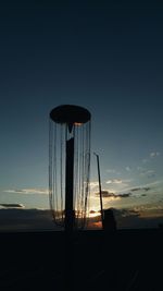 Low angle view of silhouette cranes against sky during sunset