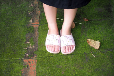 Low section of woman standing on footpath