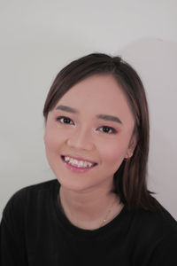 Portrait of a smiling young woman over white background