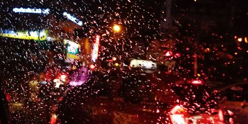 Rain drops on car windshield at night
