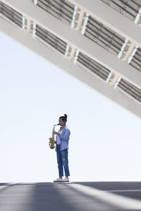 Low angle view of man standing on bridge against sky