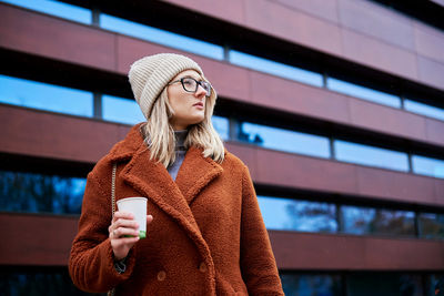 Woman at city street with coffee cup
