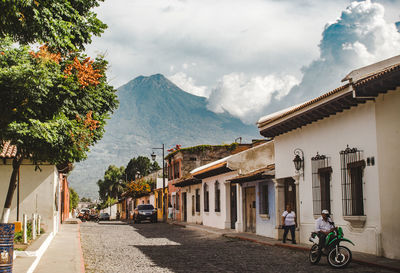 Street amidst houses and buildings against sky