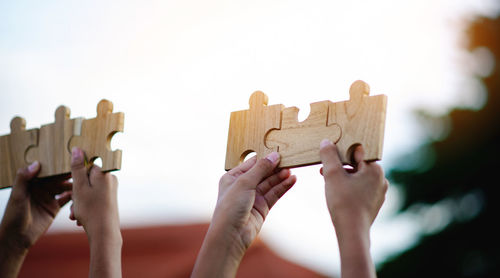 Cropped hands holding jigsaw puzzle