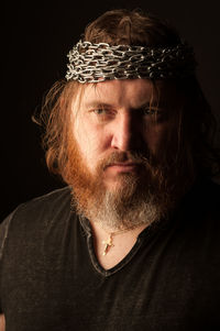 Close-up portrait of man against black background