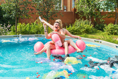 Full length of happy young man in swimming pool