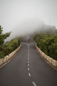 Road amidst trees against sky