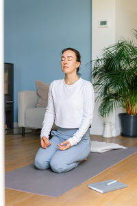 Young woman practicing meditation at home. concept of mental health and women's wellness.