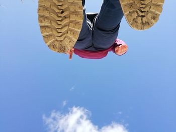 Low section of man against blue sky