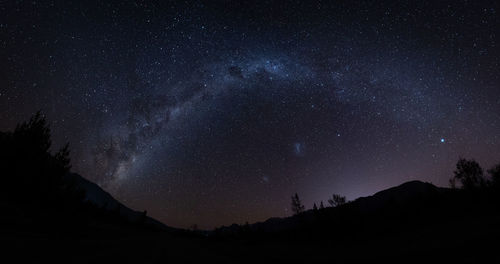 Low angle view of silhouette mountain against sky at night