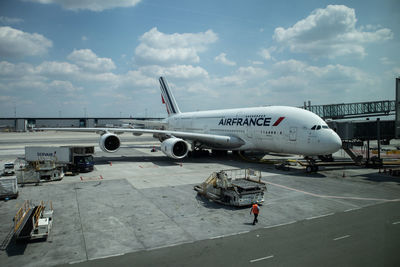 Airplane on airport runway against sky