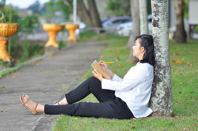 Side view of woman sitting outdoors