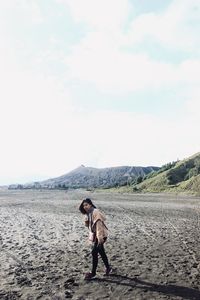 Full length of woman standing on land against sky