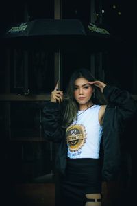 Portrait of woman standing against wall