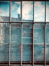 Full frame shot of glass building against sky