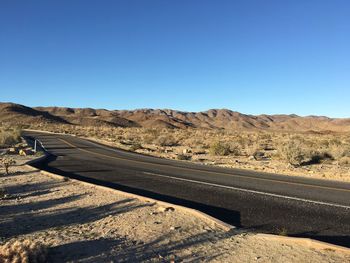 Scenic view of desert against clear blue sky