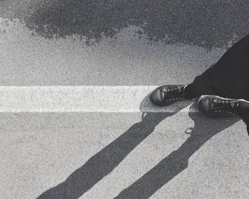 Low section of man standing on road