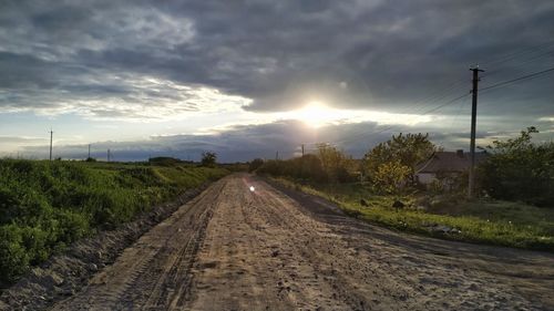 Railroad tracks by road against sky