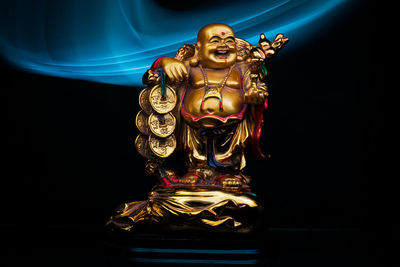 Close-up of illuminated statue against black background