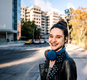 Portrait of young woman drinking water in city