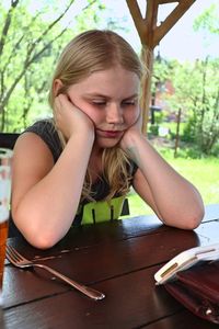 Sad girl sitting at table