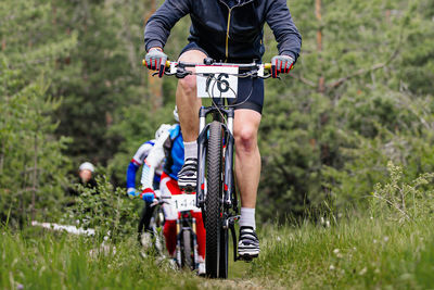 Rear view of man riding bicycle on field