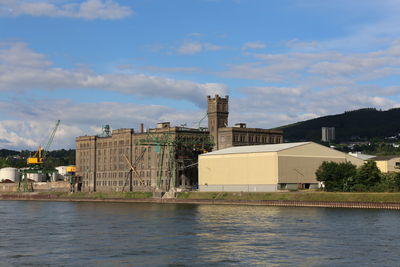 Buildings in city against cloudy sky