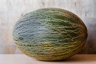 Whole piece of melon on wooden background.