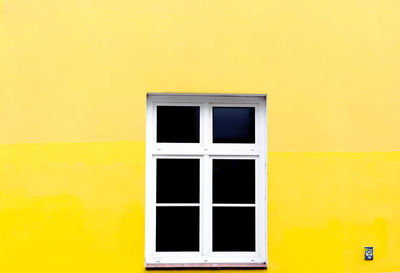 Multi colored building against yellow wall