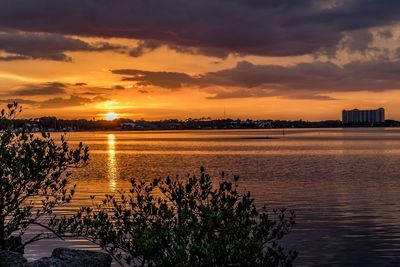 Scenic view of sea against cloudy sky during sunset