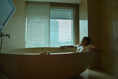 A man sitting in bathroom at home