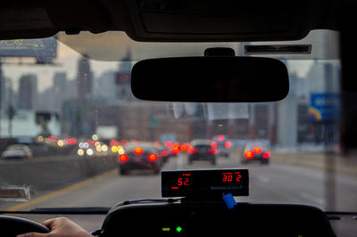 Traffic signal on road in city seen through car windshield