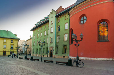 Street by buildings against sky in city