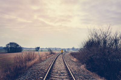 Railroad tracks against sky during sunset