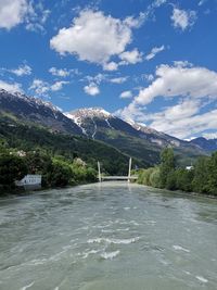 Scenic view of river by mountains against sky in innsbruck, austria 