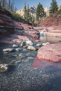Surface level of stream by rocks against sky