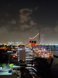 High angle view of illuminated buildings by sea against sky