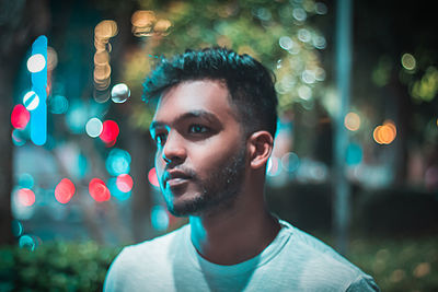 Portrait of young man looking away in city