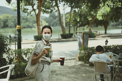 Cinematic film style of confident young women carrying reusable bag and hand holding ice beverage