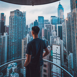 Rear view of man looking at city buildings