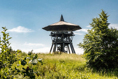 Traditional windmill on field against sky