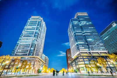 Low angle view of illuminated buildings against sky at night