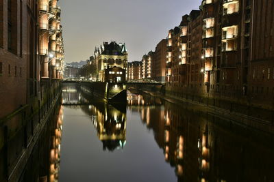 Canal passing through city buildings at night