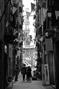 People walking on street amidst buildings in city