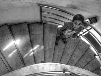 High angle view portrait of boy standing on spiral staircase