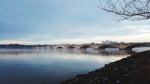 Arch bridge over river against sky