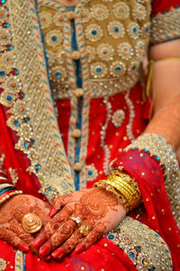 Close-up of bride with henna tattoo and red sari